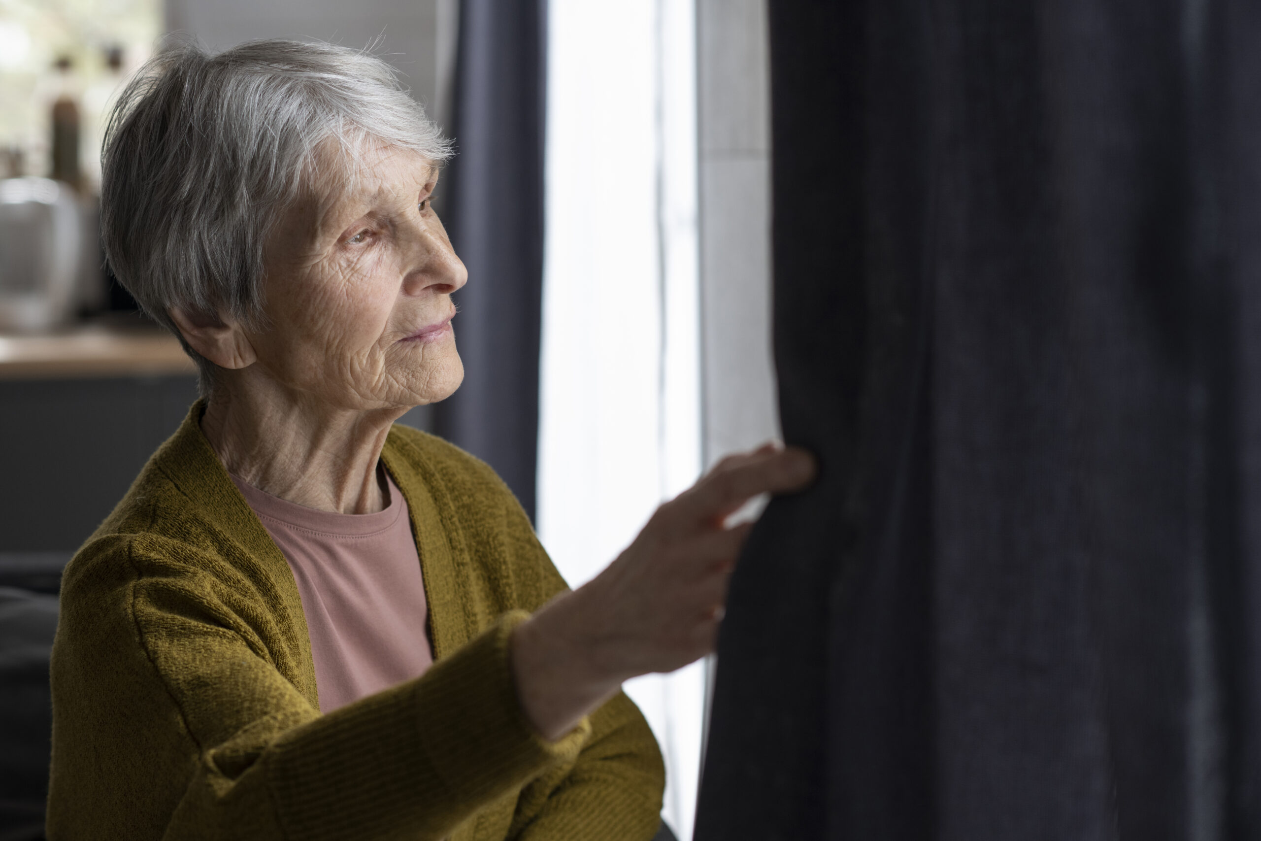 medium-shot-senior-woman-looking-out-window